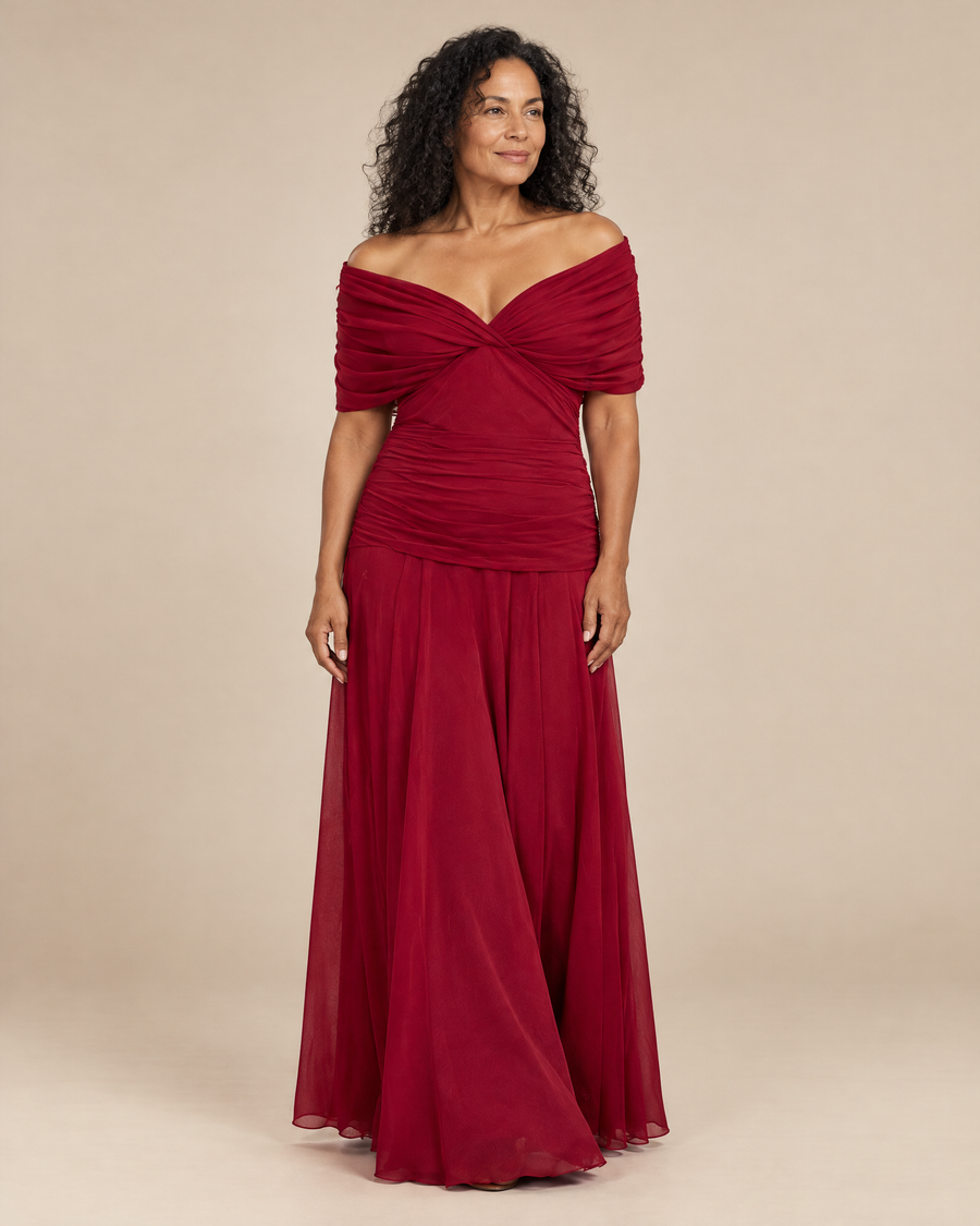 elegant red occasion dress in a light beige studio